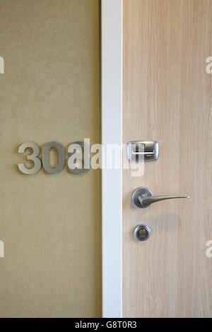 Nahaufnahme einer modernen Hotel-Tür zeigt Karten-Schlüssel betrieben Zugangskontrolle neben Nummernzeichen Metall-Zimmer Stockfoto