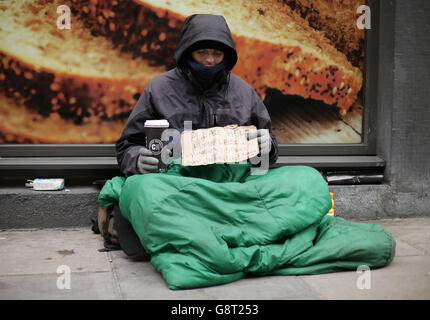 Lucas, ein Obdachloser, der ein Schild mit der Aufschrift "Bitte helfen, obdachlos und hungrig" in Victoria, London, hält. Lucas, ein Obdachloser, der ein Schild mit der Aufschrift "Bitte helfen, obdachlos und hungrig" in Victoria, London, hält. Stockfoto