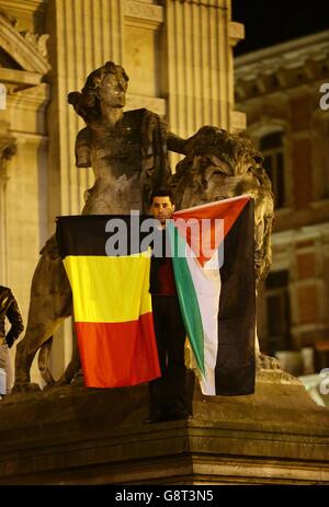 Ein Mitglied der Öffentlichkeit hält eine belgische und palästinensische Flagge auf dem Place de la Bourse in Brüssel nach den Terroranschlägen. Stockfoto