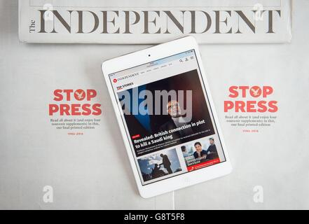 Die Independent-Website wird auf einem iPad neben Kopien der letzten Druckausgabe der Independent-Zeitung angezeigt, da der Titel in ein rein digitales Format übergeht. Stockfoto