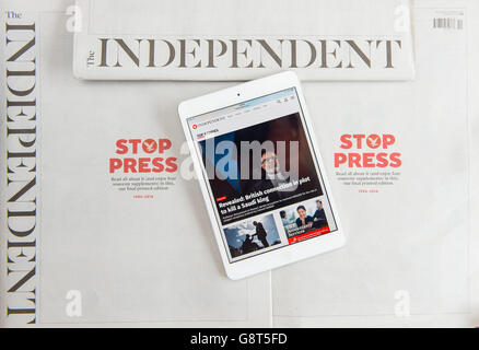 Die Independent-Website wird auf einem iPad neben Kopien der letzten Druckausgabe der Independent-Zeitung angezeigt, da der Titel in ein rein digitales Format übergeht. Stockfoto