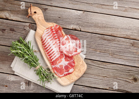 Schinken und Rosmarin auf Holztisch. Draufsicht mit Textfreiraum Stockfoto