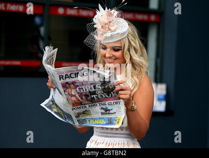 Eine weibliche Rennfahrerin liest die Racing Post während des Ladies Day des Crabbie's Grand National Festivals auf der Aintree Racecourse, Liverpool. Stockfoto