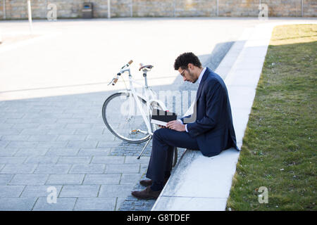 Geschäftsmann mit dem Fahrrad eine Pause in der Stadt Stockfoto