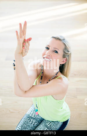 Blonde Frau praktizieren Yoga-Pose in der Klasse Stockfoto