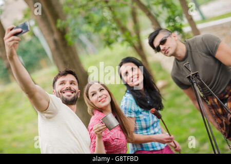 Gruppe von Freunden unter Selfies auf Campingplatz Stockfoto