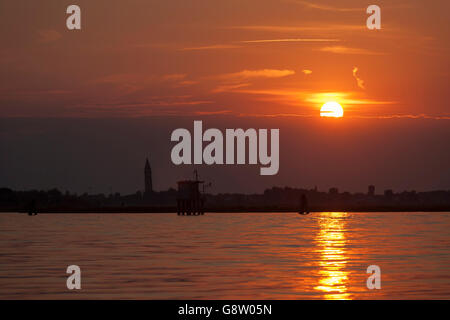 Der schiefe Turm von Burano Kirche bei Sonnenuntergang von Treporti, Lagune von Venedig, Italien Stockfoto