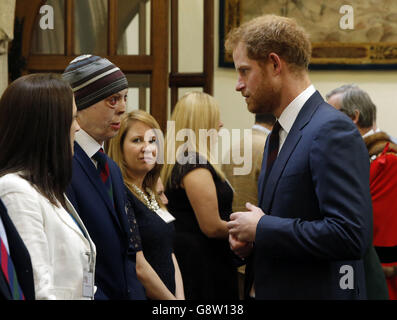 Prinz Harry (rechts) spricht mit Martyn Compton (2. Links), einem ehemaligen britischen Soldaten des Haushalts-Kavallerie-Regiments, der seine Verletzungen erlitten hat, nachdem ein RPG sein Fahrzeug in Afghanistan in Brand gesetzt hatte, beim großen Curry-Mittagessen des Oberbürgermeisters zugunsten des ABF (Army Benevolent Fund), der Soldier's Charity, In der Guildhall in London. Stockfoto