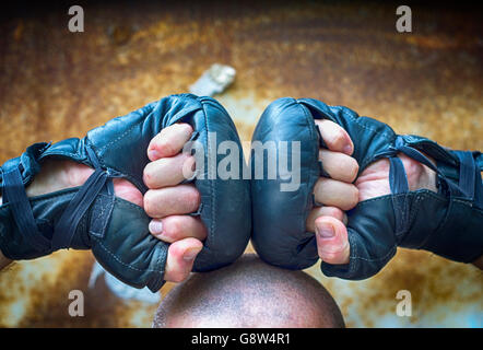 Zwei Hände geballt in eine Faust in für Boxhandschuhe liegen auf den Kopf Stockfoto