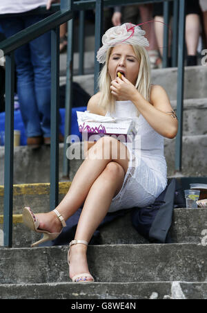 Während des Scottish Grand National Day genießt eine Frau beim Coral Scottish Grand National Festival auf der Ayr Racecourse etwas zu essen. Stockfoto