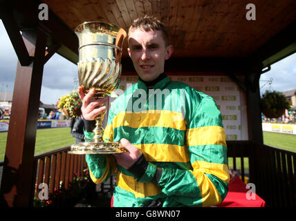 Jockey Mark Walsh mit der Trophäe nach seiner siegreichen Fahrt auf Quantitativeasing in der FBD Cross Country Chase für den La Touche Cup am dritten Tag des Punchestown Festivals in Punchestown, Co. Kildare, Irland. Stockfoto