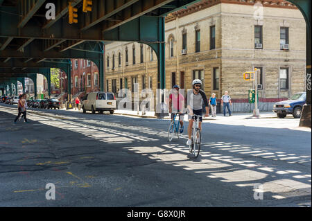 Radfahrer unter den erhöhten verfolgt Flushing Line in Long Island City im Stadtteil Queens in New York auf Sonntag, 26. Juni 2016. Nach einer Reihe von Befragungen Königinnen, besonders Western Queens mit seiner Nähe nach Midtown Manhattan, ist bereit, den nächsten trendigen Ort, Brooklyn verdrängen werden. (© Richard B. Levine) Stockfoto