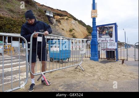 Weitere Barrieren befinden sich vor der eingestürzten Klippe neben der Seilbahn East Cliff am Bournemouth Beach, die beschädigt wurde, nachdem durch einen riesigen Erdrutsch Tonnen von Schutt auf einem Küstenresort zusammengebrochen waren. Stockfoto