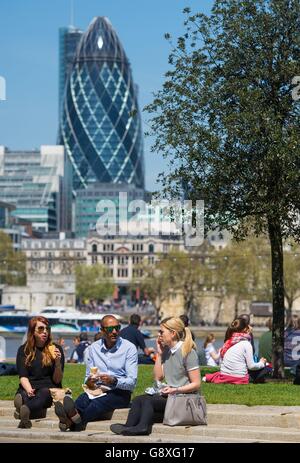 Im Potters Field Park in London essen die Menschen in der Sonne zu Mittag, da viele Teile Großbritanniens einen Tag mit warmem Wetter genießen. Stockfoto
