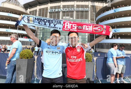 Ein Manchester City-Fan posiert mit einem Arsenal-Fan vor dem Barclays Premier League-Spiel im Etihad Stadium in Manchester. Stockfoto