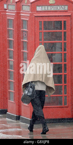 In der Regent Street, London, werden die Menschen in einem heftigen Regenguss gefangen. Stockfoto