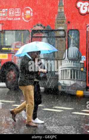 In der Regent Street, London, werden die Menschen in einem heftigen Regenguss gefangen. Stockfoto