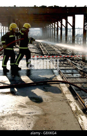 Feuerwehrleute weiter dämpfen am Southend Pier Bahnhof Montag 10 2005. Oktober. Nach einem Brand entbrannte der Bahnhof und ein Restaurant am Ende der Pier gestern Abend. Rund 60 Feuerwehrleute nahmen Flammen springen 30 bis 40 Meter in die Luft als die absolut riesige Inferno verschlang bis zu 130 Meter von der Struktur in Essex - die weltweit längste Vergnügen Pier sehen PA Story FIRE Pier.. PRESSEVERBAND FOTO-Kredit sollte Chris Radburn/PA lesen Stockfoto