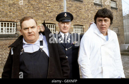 Old lag Fletcher (Ronnie Barker), Mitgefangener Godber (Richard Beckinsale) und Gefängnisbeamter Mackay (Fulton Mackay) während Drehorte für die Filmversion ihrer TV-Serie 'Porridge' im Chelmsford Gefängnis, die seit einem Brand im letzten Jahr leer war. Stockfoto