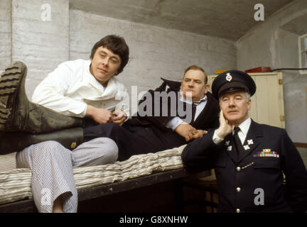 Old lag Fletcher (Ronnie Barker), Mitgefangener Godber (Richard Beckinsale) und Gefängnisbeamter Mackay (Fulton Mackay) während Drehorte für die Filmversion ihrer TV-Serie 'Porridge' im Chelmsford Gefängnis, die seit einem Brand im letzten Jahr leer war. Stockfoto