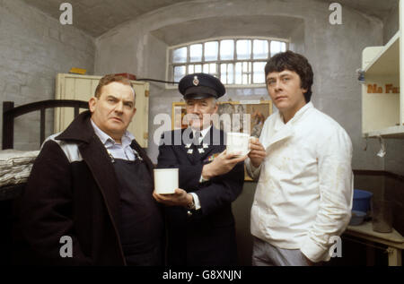 Old lag Fletcher (Ronnie Barker), Mitgefangener Godber (Richard Beckinsale) und Gefängnisbeamter Mackay (Fulton Mackay) während Drehorte für die Filmversion ihrer TV-Serie 'Porridge' im Chelmsford Gefängnis, die seit einem Brand im letzten Jahr leer war. Stockfoto