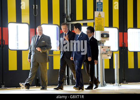 Depotmanager George Staines (links), Premierminister David Cameron und der japanische Premierminister Shinzo Abe (zweiter rechts) besichtigen das Hitachi North Pole Train Maintenance Depot in West London, da Abe davor gewarnt hat, dass der Brexit Großbritannien für japanische Investoren "weniger attraktiv" machen würde. Stockfoto