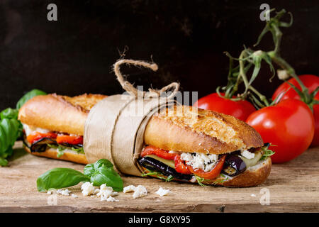 Tapeziert vegetarische Baguette u-Boot-Sandwich mit gegrillter Aubergine, Paprika und Feta-Käse auf Holz hacken über dunkel an Bord Stockfoto