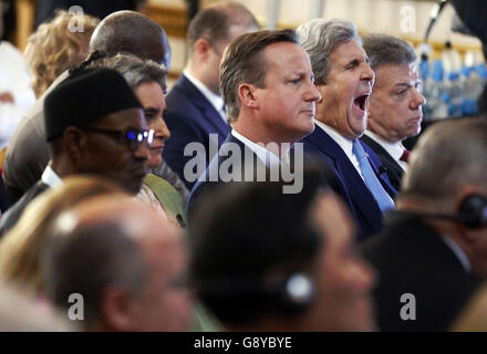 Premierminister David Cameron sitzt neben US-Außenminister John Kerry, während sie einem Panel beim Anti-Korruptions-Gipfel im Lancaster House in London lauschen. Stockfoto