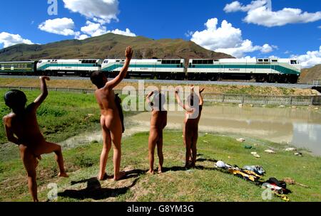 (160630)--Peking, 30. Juni 2016 (Xinhua)--Datei Foto aufgenommen am 21. Juli 2006 zeigt die lokalen Kinder winken für einer Bahn auf der Qinghai-Tibet-Eisenbahn in Duilong Deqing County von Südwesten Chinas Tibet autonome Region. Die Qinghai-Tibet-Eisenbahn wird 10 am 1. Juli 2016. Die 1.956 Kilometer lange Bahn, die Service im Juli 2006 begann, ist der weltweit höchste und längste Plateau Eisenbahn und auch die erste Eisenbahn der Tibet autonomen Region mit anderen Teilen von China zu verbinden. Ökologischen Schutzmaßnahmen während und nach dem Bau der Eisenbahn haben dafür gesorgt, dass es war Stockfoto