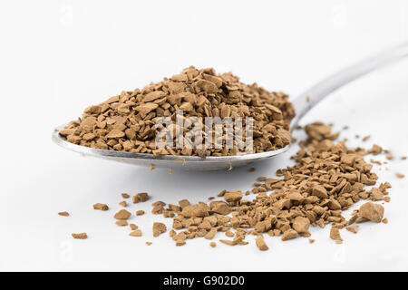 Fokus auf Premium braun entkoffeinierten Kaffeepulver putting auf Edelstahl Teelöffel und weißen Boden, die auf weißen bac isoliert zu schließen Stockfoto