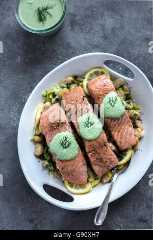 Eine Platte, weiße Butter Bohnen mit Ofen gebacken Lachsscheiben gekrönt, wird aus der Vorderansicht fotografiert. aus der oberen (fotografiert Stockfoto