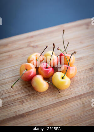 Schön, süß und lecker Rainier Kirschen auf einen Bambus Schneidbrett. Stockfoto