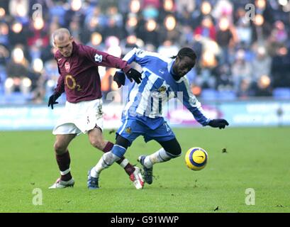Pascal Chimbonda von Wigan Athletic stampft mit Fredrik Ljungberg von Arsenal Stockfoto