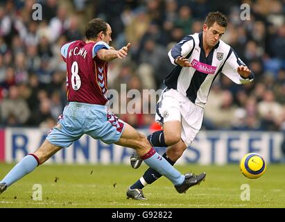 Fußball - FA Barclays Premiership - West Bromwich Albion / Aston Villa - The Hawthorns. Darren Carter von West Bromwich Albion geht am ausgestreckten Bein von Gavin McCann von Aston Villa vorbei Stockfoto