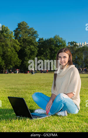 glückliche junge Studentin Frau mit Laptop im Stadtpark Stockfoto