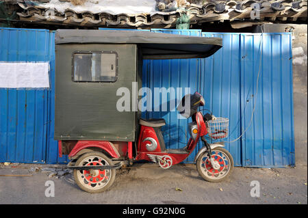 Rikscha geparkt in einem Hutong in Peking, China Stockfoto