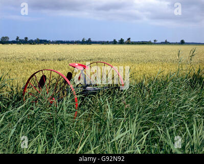 verlassene historische Landmaschinen in einem Feld Stockfoto