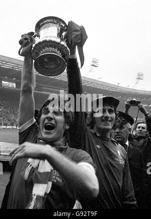 Liverpools Kapitän Emlyn Hughes (links) und Torwart Ray Clemence schmeissen den FA Cup nach dem Sieg von Liverpools 3-0 freudig an die Fans. 166328-38 Stockfoto