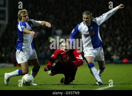 Wayne Rooney (C) von Manchester United wird von Michael Grey (L) von Blackburn Rovers und Tugay während des ersten Halbfinalmatches im Carling Cup in Ewood Park, Blackburn, Mittwoch, 11. Januar 2006, herausgefordert. DRÜCKEN Sie VERBANDSFOTO. Bildnachweis sollte lauten: Nick Potts/PA. Stockfoto