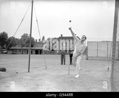 Der englische Jim Laker kegelt in den Netzen, um seine Eignung für den zweiten Test zu beweisen, wie MCC-Assistent SC Griffith (Hintergrund, zweites l) anschaut Stockfoto