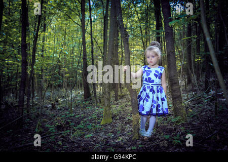 kleines Mädchen allein zu Fuß in den Wald, Buch-Cover-Stil Stockfoto