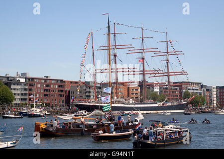 AMSTERDAM, Niederlande, 20. August 2015 Besucher in Booten beobachten die schönen großen Großseglern während der großen sogar Segeln Stockfoto