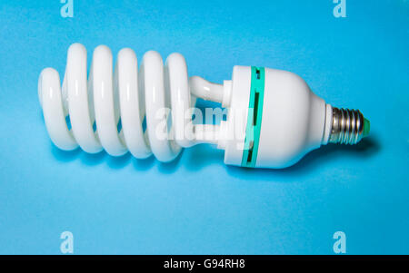 Energiesparende Glühbirne auf blauem Hintergrund Stockfoto