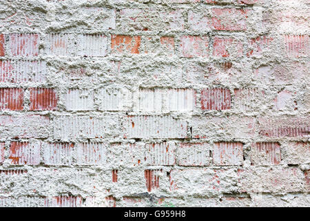 rau weiß lackierten Ziegelwand mit Gips bleibt Stockfoto