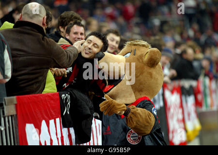 Fußball - UEFA Champions League - 16. Runde - Erstes Bein - Bayern München / AC Mailand - Allianz Arena. Die Fans des AC Mailand posieren für Bilder mit dem Maskottchen Bayern München Stockfoto