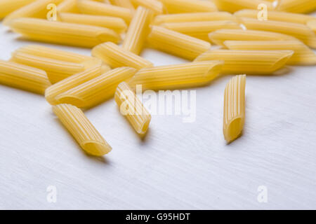 Rohe ungekochte Penne-Nudeln auf weißen Tisch Stockfoto