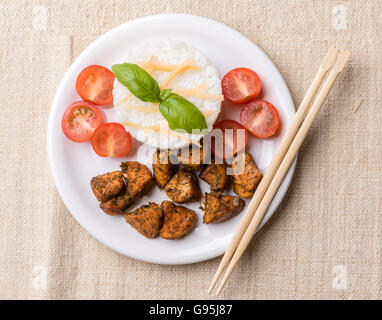 Huhn mit Reis und Tomaten auf weißen Teller Stockfoto