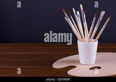 Satz von Malerei Pinsel und sauber Palette auf Schreibtisch aus Holz. Textfreiraum Stockfoto