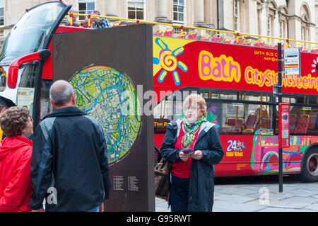 Touristen in Bath, Somerset, England, UK, schauen Sie sich eine Karte der Kurstadt Stockfoto
