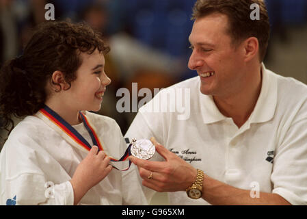 Nick Gilligham lässt den jungen Schwimmer Chantal Carr, 9, aus Glasgow, seine olympische Silbermedaille für die Größe ausprobieren, als er seine Rückkehr zum Wettkampfschwimmen bei der Schwimmweltmeisterschaft in Glasgow ankündigt Stockfoto